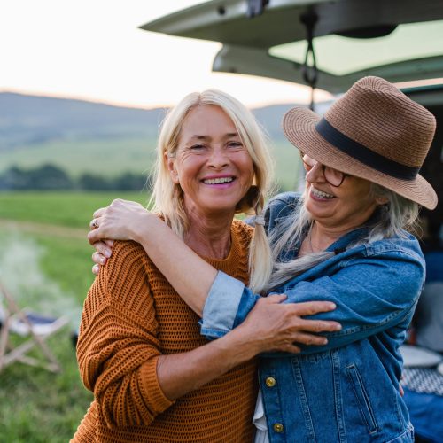 Senior women friends looking at camera outdoors in nature