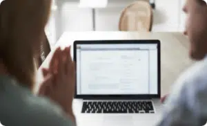 People viewing computer monitor of resource lists