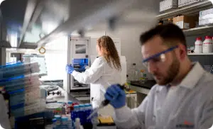 Two Arvinas scientific staff members conducting tests at different stations in lab