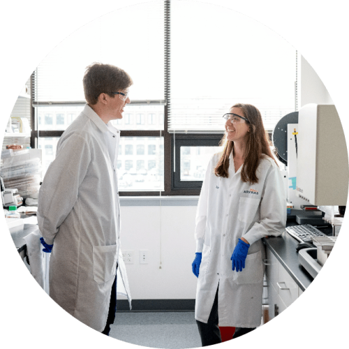 Two Arvinas scientific staffers holding conversation in front of window in lab